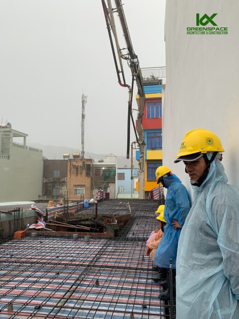 Công nhân xây dựng gặp khó khăn khi xây nhà mùa mưa. 